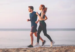 young couple jogging by the beach