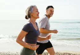 older couple running on the beach